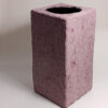 A pink colored rectangular papier mache vase