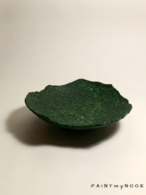 A deep green colored papier mache bowl
