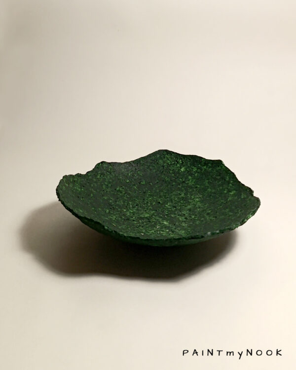A deep green colored papier mache bowl