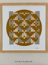 Framed wall decor featuring a yellow ochre paperweaving project