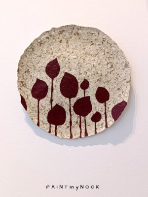 A hand painted papier mache decorative plate featuring deep red pertals