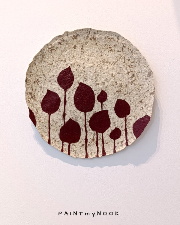 A hand painted papier mache decorative plate featuring deep red pertals