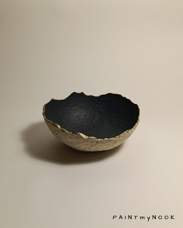 a papier mache bowl with a gold rim and black color