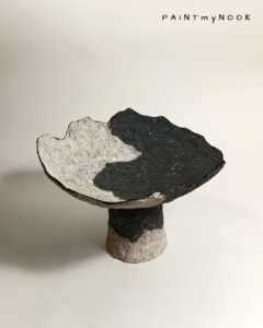 A two colored papier mache bowl with foot
