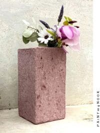 A dusty pink colored rectangular papier mache vase
