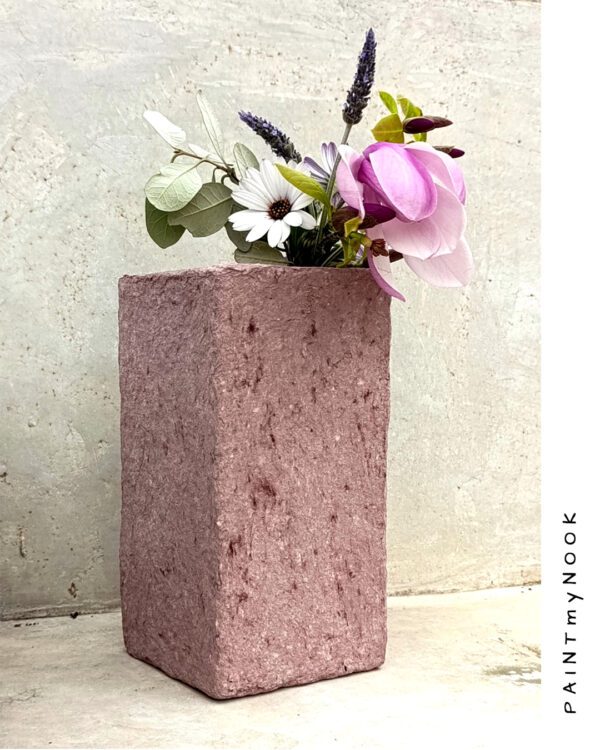 A dusty pink colored rectangular papier mache vase
