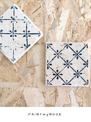 A travertine coaster with a linocut print on in deep blue color