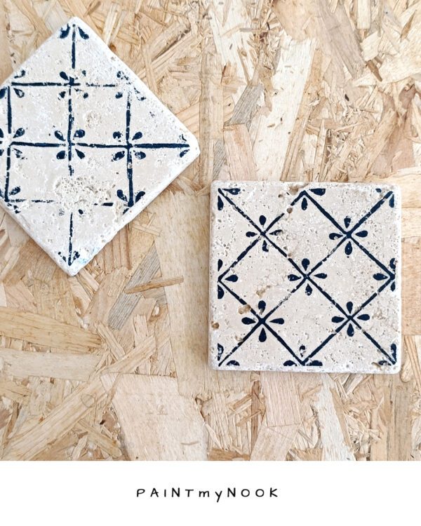 A travertine coaster with a linocut print on in deep blue color