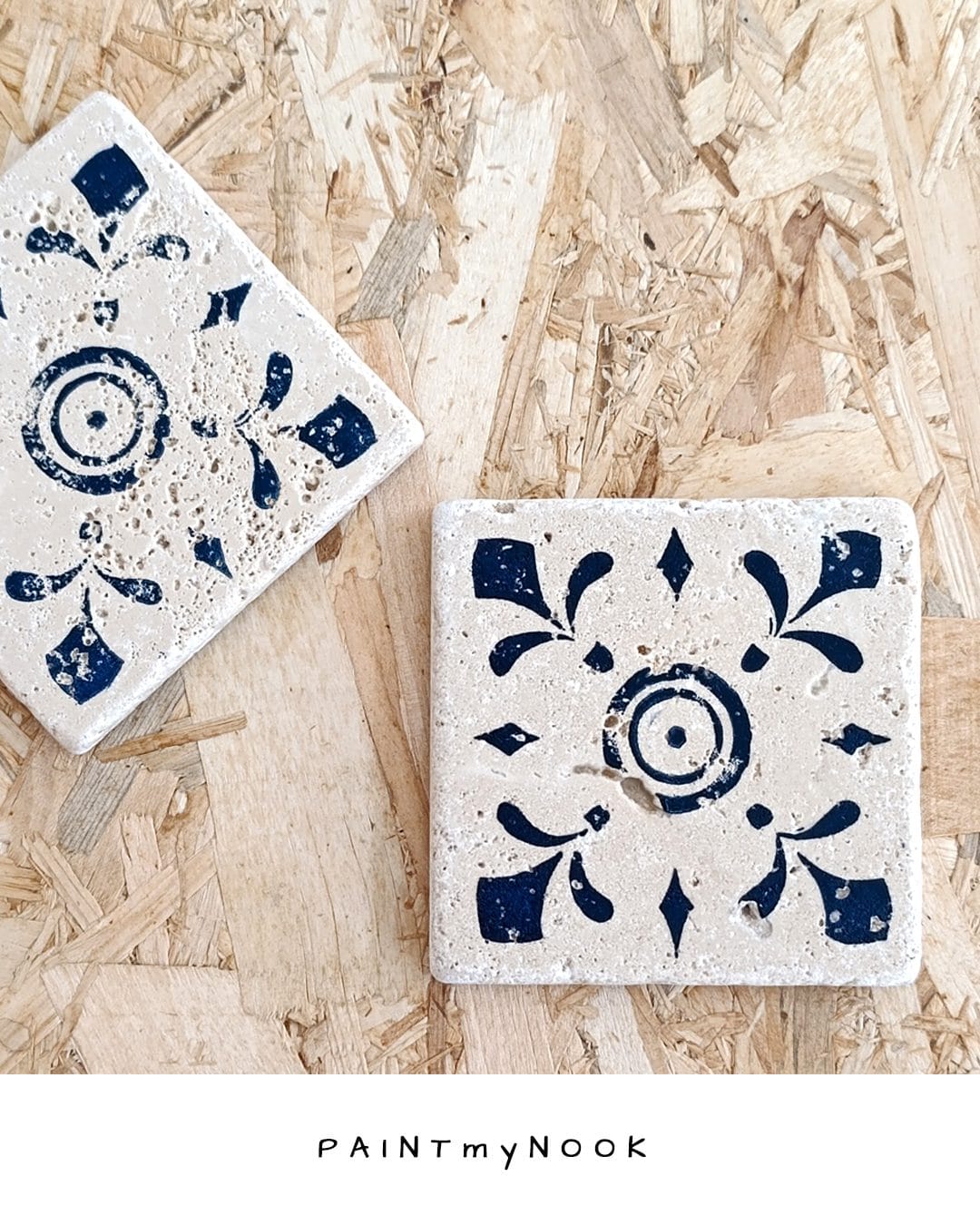 A travertine tile coaster with a deep blue linoprint on