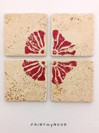 Four travertine coasters with a red flower print
