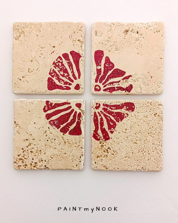 Four travertine coasters with a red flower print