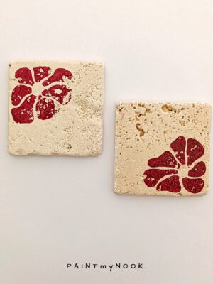 Two travertine coasters with a red flower print
