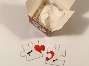 A small red box opened and two puzzle pieces